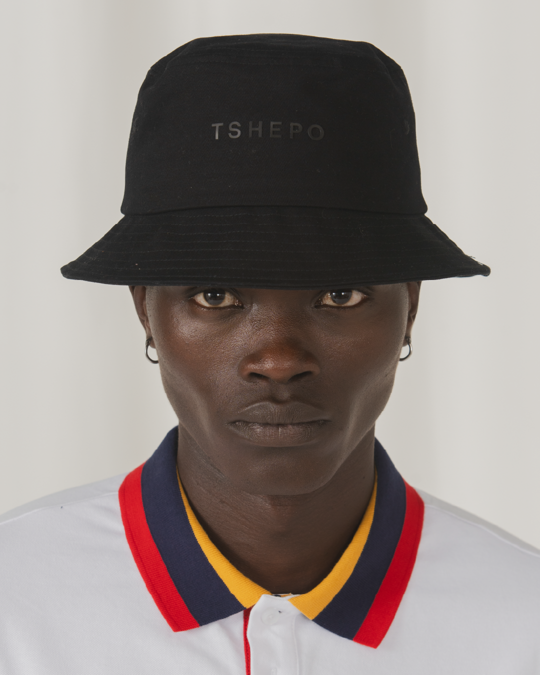 Up close image of the TSHEPO POLO with flag coloured collar.