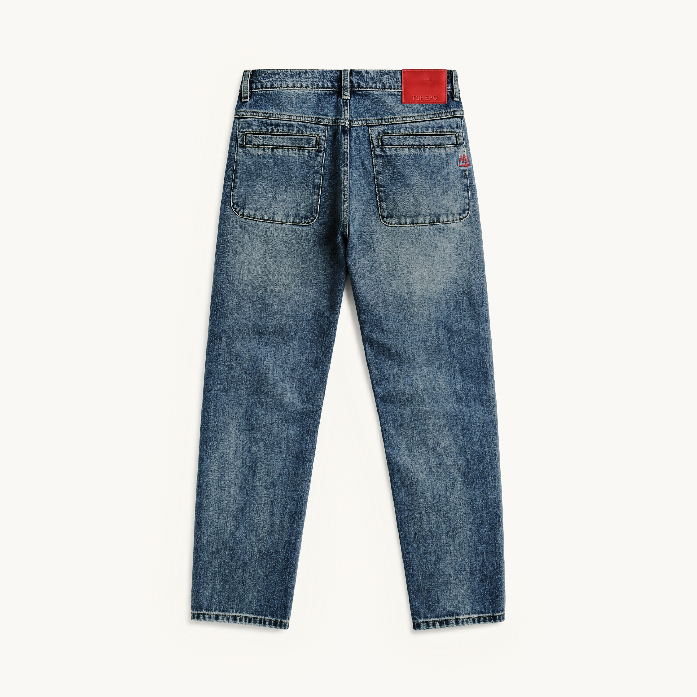 Back view of TSHEPO VY Straight Leg blue denim jeans with a faded wash, featuring a red leather patch on the back waistband and a small red embroidered crown logo on the pocket.