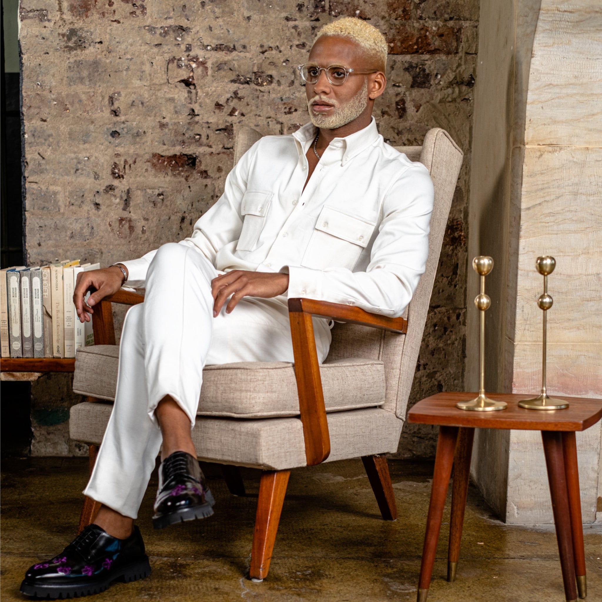 TSHEPO Model wearing a set in a tobacco colour sitting on a wooden chair with a rustic background.